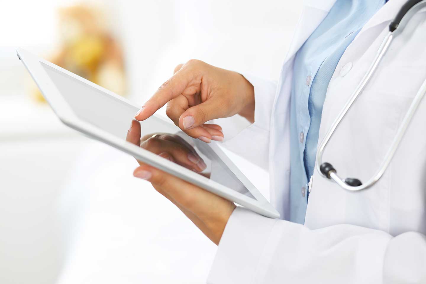 Arzt bedient Tablet in der digitalen Therapiebegleitung
